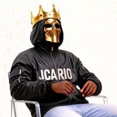 JCARIO in a gold mask and crown, wearing a black JCARIO jacket